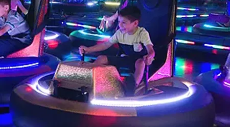 Boy driving LED bumper car at SacTag indoor amusement center