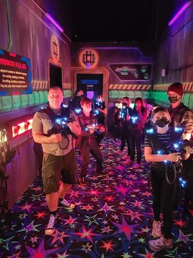 Players battling inside the neon-lit indoor laser tag arena at SacTag.