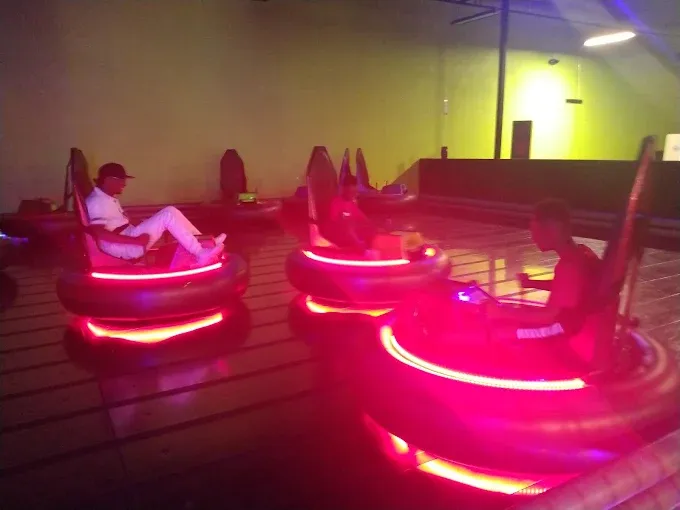 Indoor bumper cars with neon lighting for corporate team fun.