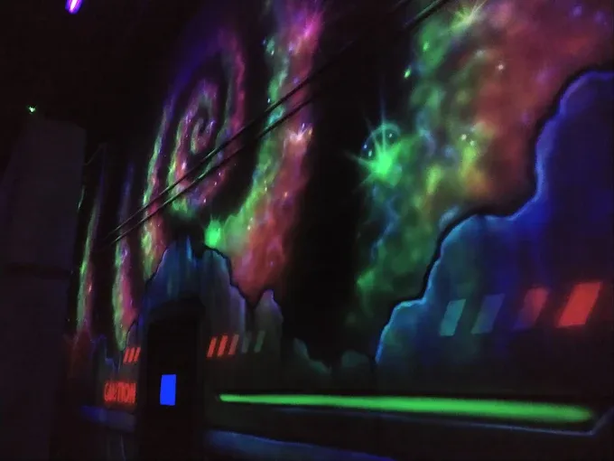 Sci-fi mural and neon lighting inside Sacramento's only two-story laser tag arena.